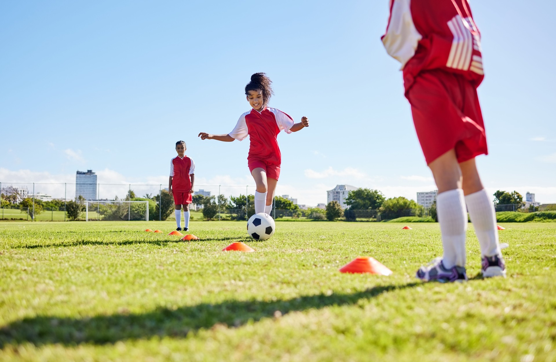 Football, entraînement ou course à pied et une équipe de filles jouant avec un ballon ensemble sur un terrain pour l’entraînement. Fitness, football et gazon avec des enfants sportifs dribblant sur un terrain pour la compétition ou l’exercice